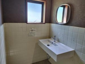 a bathroom with a sink and a mirror at 民宿 とうの浜 in Yasuda