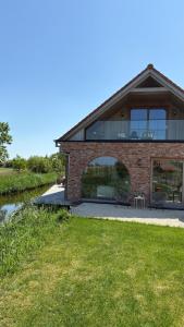 a brick house with two chairs in front of it at B&B Les Trois Pignons in Diksmuide