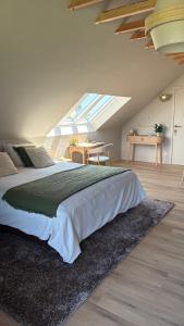 a bedroom with a large bed and a table at B&B Les Trois Pignons in Diksmuide
