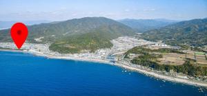 a red object is flying over the ocean at 民宿 とうの浜 in Yasuda