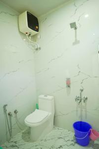 a bathroom with a toilet and a tv on the wall at Kabila King Resort in Chakrāta