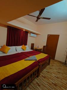 a bedroom with two beds and a ceiling fan at Quality Inn Resort in Varkala