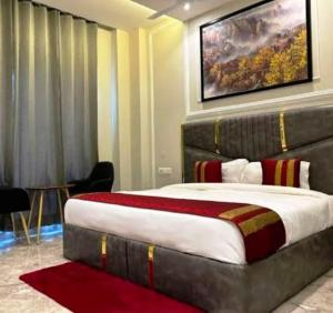 a bedroom with a large bed with a painting above it at Premium Radhe Dham Hotel & Restaurant - Fully AC - Only 5 Min Drive to Prem Mandir, Newly Build in Vrindāvan +16 photos