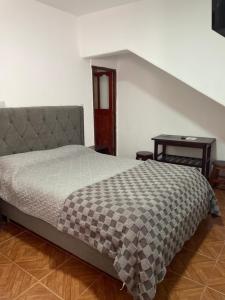 a bedroom with a bed and a table in it at TIlcara Rooms in Tilcara