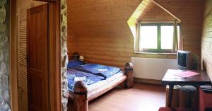 sypialnia z łóżkiem w drewnianym domku w obiekcie Zrub Benango w mieście Mięguszowce