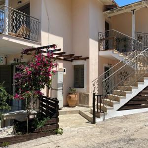 a building with stairs and flowers on the side at Μπουκαμβίλια - Bougainvillea in Sivota