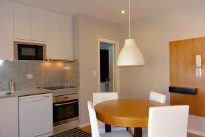 cocina con mesa de madera y armarios blancos en Júlio Dinis Flat, by Flat in Porto en Oporto