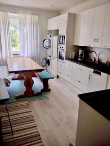 a kitchen with a wooden table and white cabinets at Aliupseerikerho in Kauhava