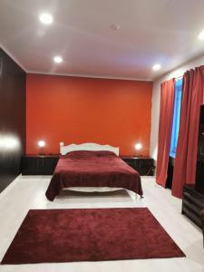 a bedroom with a large bed with an orange wall at Aliupseerikerho in Kauhava +9 photos