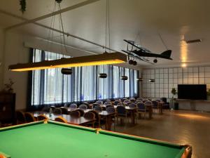 a pool table in a room with chairs and an airplane at Aliupseerikerho in Kauhava