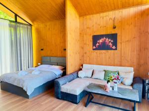 ein Schlafzimmer mit zwei Betten und einer Couch in der Unterkunft Tianuli in Tushurebi
