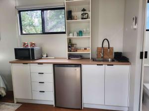 a kitchen with a counter with a microwave and a sink at Rosebank Tiny House in Healesville