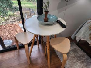 a small table with a bowl and a remote control on it at Rosebank Tiny House in Healesville
