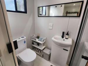 a small bathroom with a toilet and a sink at Rosebank Tiny House in Healesville