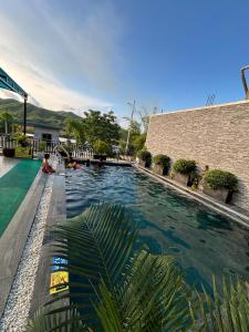 a swimming pool next to a brick building at TuTu's Homestay Phong Nha in Phong Nha