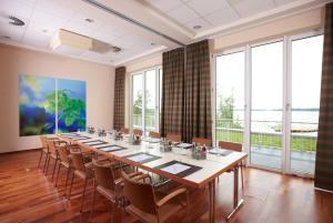 ein großer Konferenzraum mit einem langen Tisch und Stühlen in der Unterkunft Seehotel Fleesensee in Göhren-Lebbin + 37 Fotos
