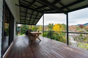 a deck with a table and a view of the mountains at High Country on Perkins in Jamieson