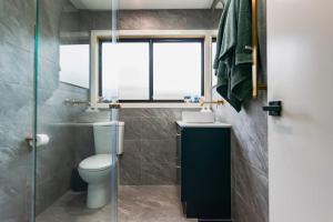 a bathroom with a toilet and a sink and a window at High Country on Perkins in Jamieson +10 photos