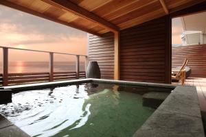 a swimming pool on the balcony of a house with the ocean at ゆうみ in Kyonan