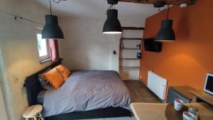 a bedroom with a bed and a desk and lights at La P'tite Brique in Rochefort