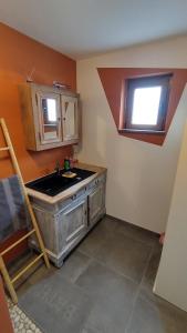 a kitchen with a sink and a window at La P'tite Brique in Rochefort