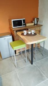 a small kitchen with a table and a microwave at La P'tite Brique in Rochefort