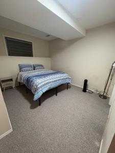a bedroom with a bed in the corner of a room at Lower Suite- 10 minutes away from airport in Calgary
