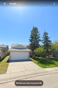 a house with a white garage on a street at Lower Suite- 10 minutes away from airport in Calgary