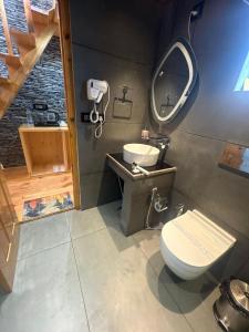 a bathroom with a toilet and a sink at The Pravaas Resort in Barot 