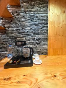 a table with a coffee maker and a cup on it at The Pravaas Resort in Barot 