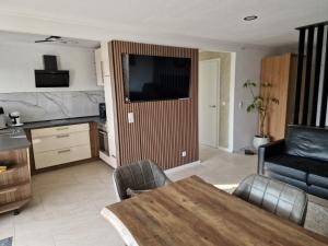 a living room with a table and a kitchen at Ferienhaus Holstein in Butjadingen +5 photos