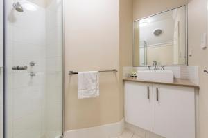 a bathroom with a shower and a sink and a mirror at Serenity Townhouse in Mandurah +9 photos