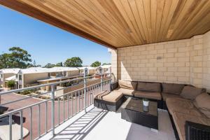 a balcony with a couch and a wooden ceiling at Serenity Townhouse in Mandurah