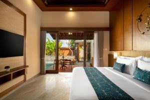 a bedroom with a bed and a tv and a patio at Sarva Ubud Villas & Spa in Ubud +33 photos