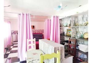 a room with pink curtains and a table and chairs at OYO 1214 Cherry Travellers Inn in San Jose de Buenavista +20 photos