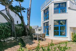 a patio with a table and chairs in front of a house at Les terrasses de Joce in Batz-sur-Mer