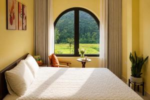 a bedroom with a bed and a large window at Tam Cốc AppA House in Ninh Binh