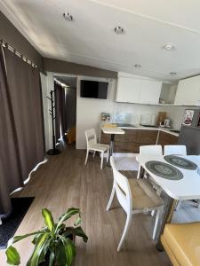 a kitchen and living room with a table and chairs at Cseresznyés Házikók in Lipót