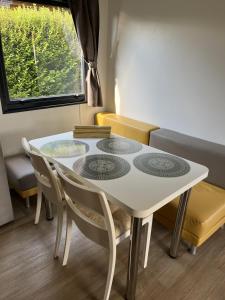 a white table and chairs in a room with a window at Cseresznyés Házikók in Lipót