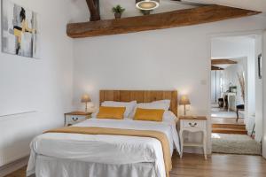 a bedroom with a large bed with white sheets and orange pillows at Aux Charmes D'antan - Chambre in Sevremont +67 photos