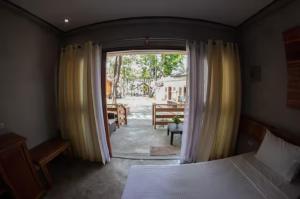 a bedroom with a bed and a large window at Republika Beach Resort in San Juan