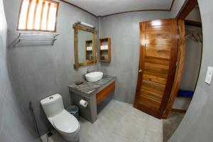 a bathroom with a toilet and a sink and a mirror at Republika Beach Resort in San Juan +72 photos