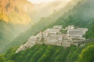 a group of white buildings on a mountain at Ginger Katra in Katra