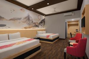 a hotel room with two beds and two chairs at Ginger Katra in Katra +12 photos