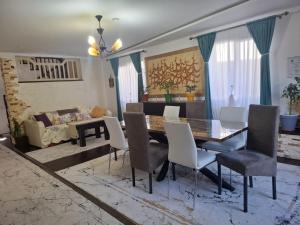 a dining room with a table and chairs and a couch at Casa de vacanta Sabrina in Gura Humorului