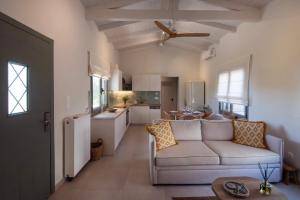 a living room with a couch and a kitchen at Leonti Maison in Egina