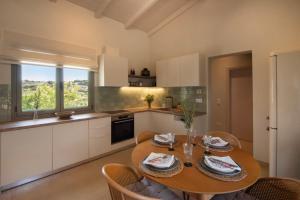 a kitchen with a wooden table and chairs in a kitchen at Leonti Maison in Egina