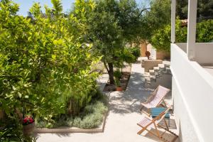 a patio with chairs and trees and plants at Leonti Maison in Egina