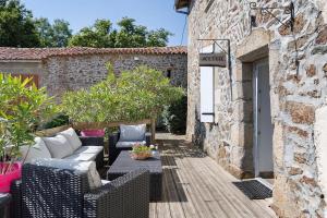 an outdoor patio with wicker furniture and a building at Aux Charmes D'antan - Chambre in Sevremont