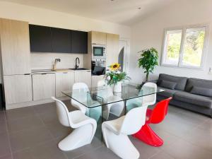 a kitchen and a dining room with a glass table and chairs at Appartement Pinede Man Yelle in Sanary-sur-Mer
